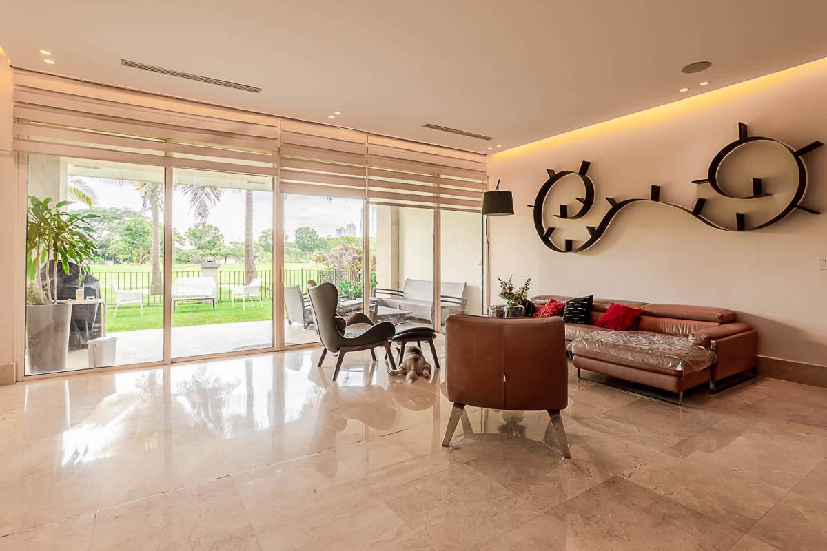 Modern open plan living room with marble floors, floor-to-ceiling glass over garden at The Reserve Santa María Panama