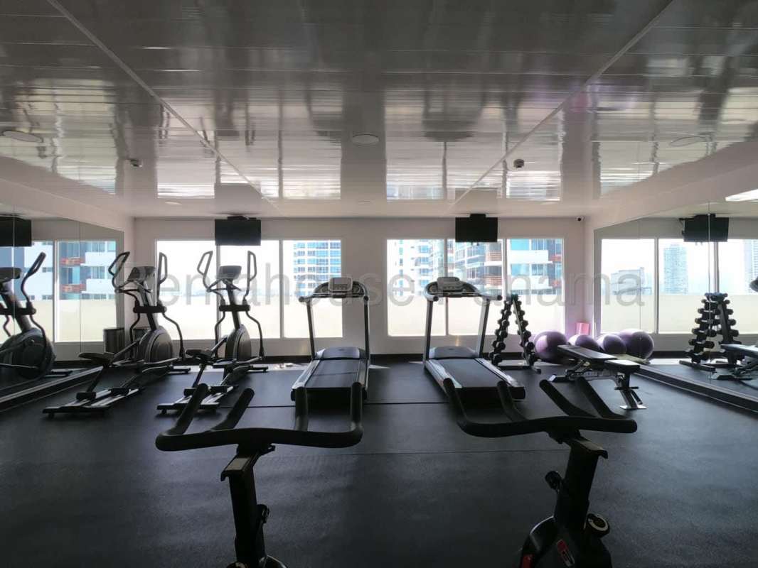 Bedroom with built-in wardrobe, air conditioning, and view of Costa del Este skyline Panama