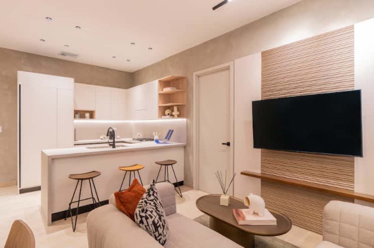 Minimalist kitchen with island, white cabinetry, wood stools in PH Ipanema Panama