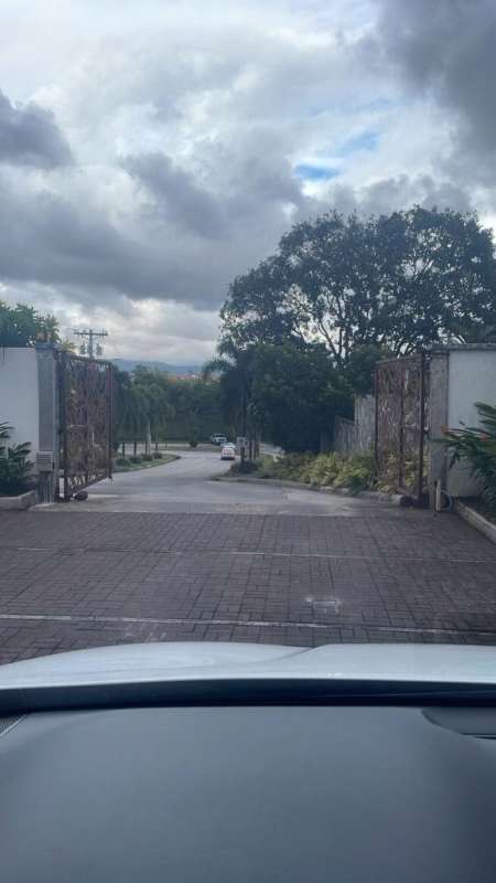 Spacious modern living room with blue sofas, TV console and tiled floors in La Reserva Villa Zaita Panama