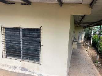 Compact bathroom with tiled walls, pedestal sink, and toilet in La Chorrera affordable rental