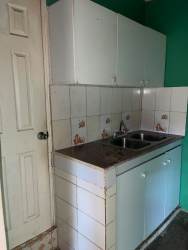 Compact kitchen with cabinets, stainless steel sink, and backsplash tile in La Chorrera apartment