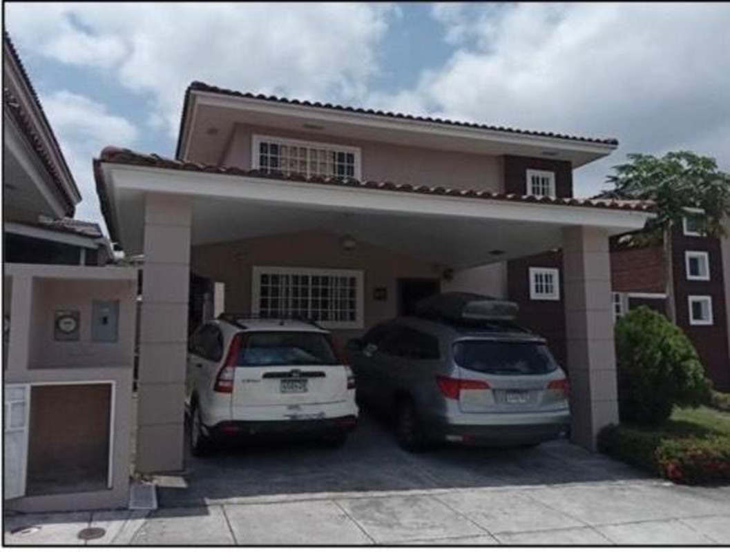 Two-story single-family house with tile roof, garage, driveway, and landscaped yard at Villa Tiber Brisas del Golf Panama City