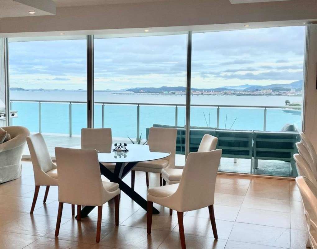 Modern dining area with glass table and ocean views in PH Aquamare Panama
