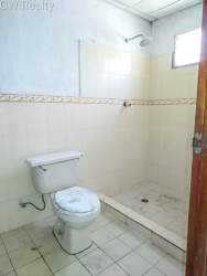 Simple bathroom with shower, toilet, tiled walls in Vacamonte Panama Oeste house