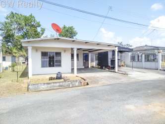 House front in Altos de las Huacas Panama with carport, barred windows, cement driveway