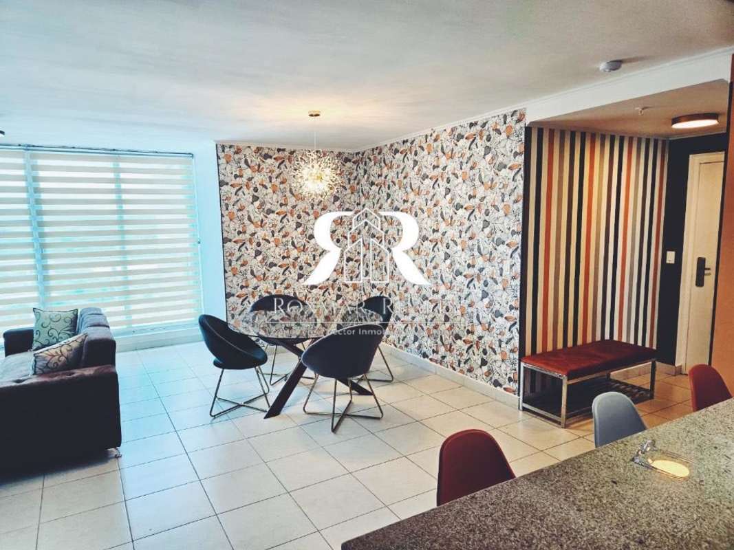 Bright open plan living dining area with accent wall, large windows, zebra blinds in PH Vía Argentina Panama