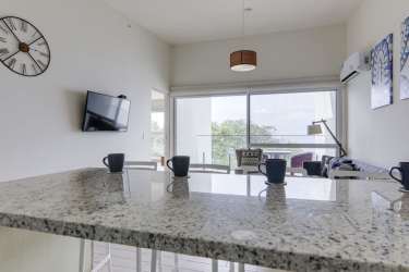 Fully equipped modern kitchen with granite counters and white cabinets in PH Solares del Mar Playa Caracol