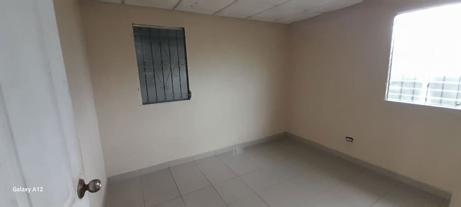 Empty bedroom with tiled floor and window bars in Don Bosco Juan Díaz