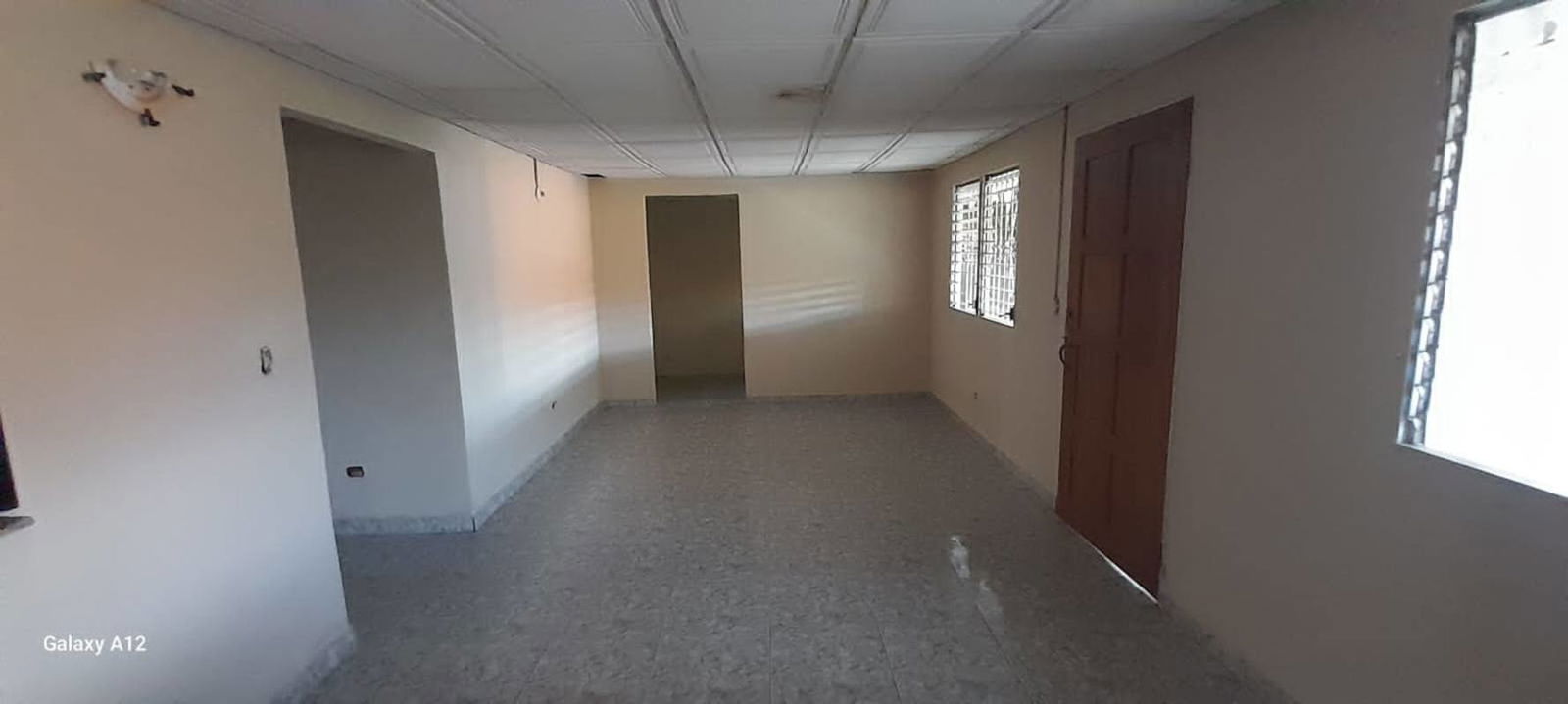Empty living room with windows bars tile floor in Don Bosco Juan Díaz house