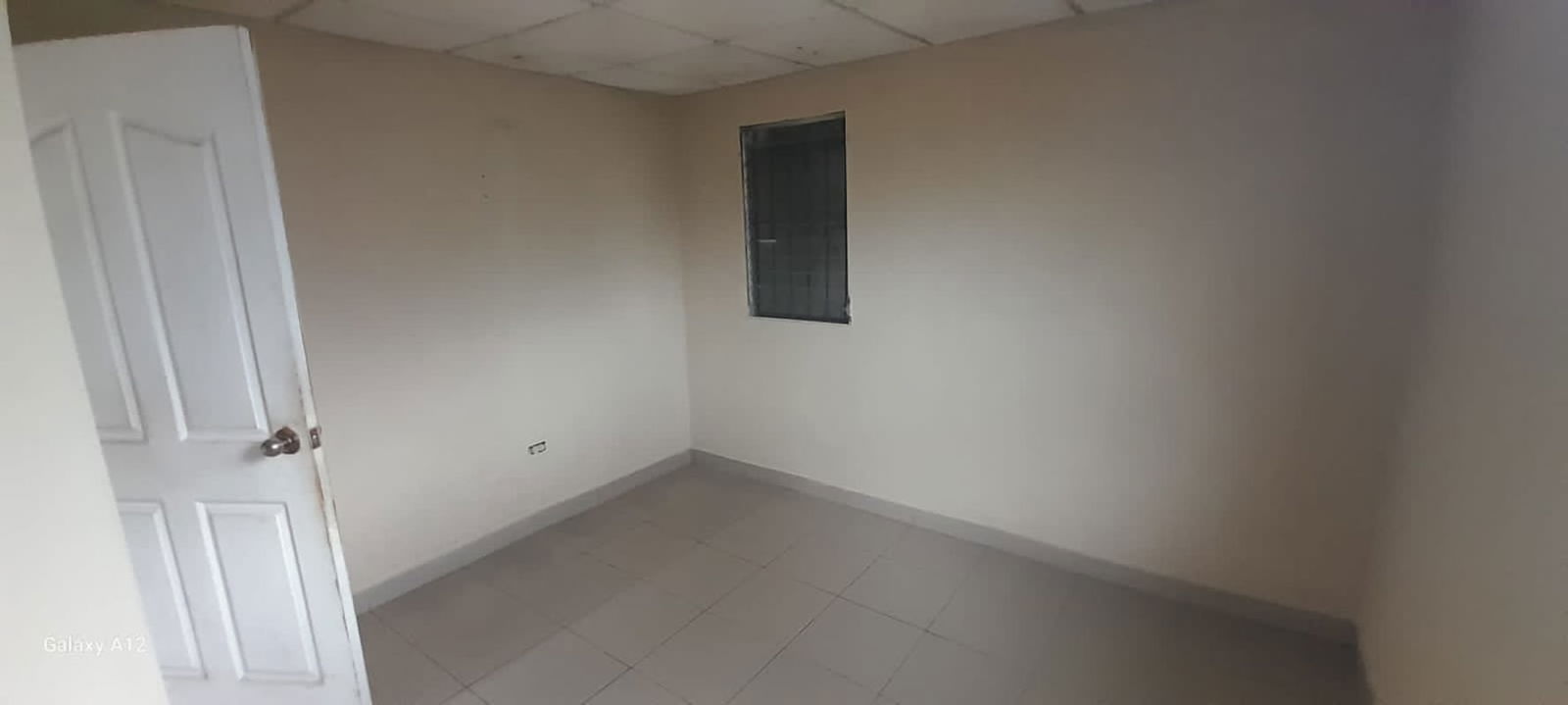 Bedroom with barred window tiled floors empty in Don Bosco house