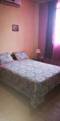 Simple bedroom with split AC, bed and nightstand at Villa Laura rental San Carlos Panama
