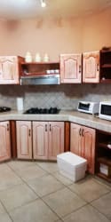 Traditional kitchen with gas stove, wood cabinets, tile backsplash Villa Laura rental San Carlos