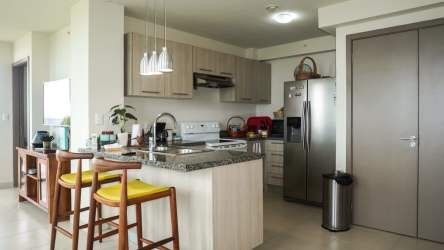 Equipped kitchen with granite countertops, wood cabinets, breakfast bar at Ensenada Beach Resort San Carlos