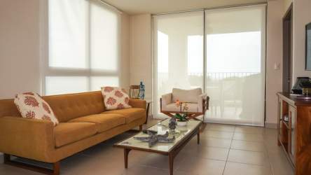 Bright living room with large windows, sliding glass doors to balcony at Ensenada Beach Resort San Carlos Panama
