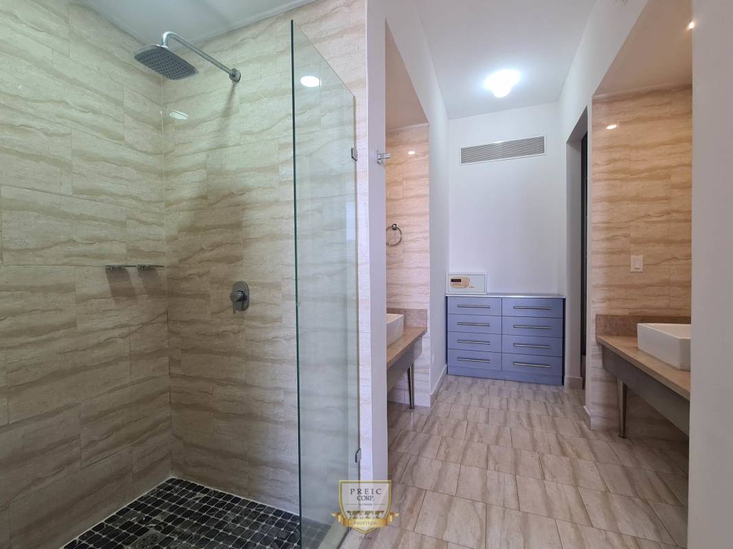 Modern bathroom with glass enclosed walk-in shower and dual sinks PH Denovo Panama