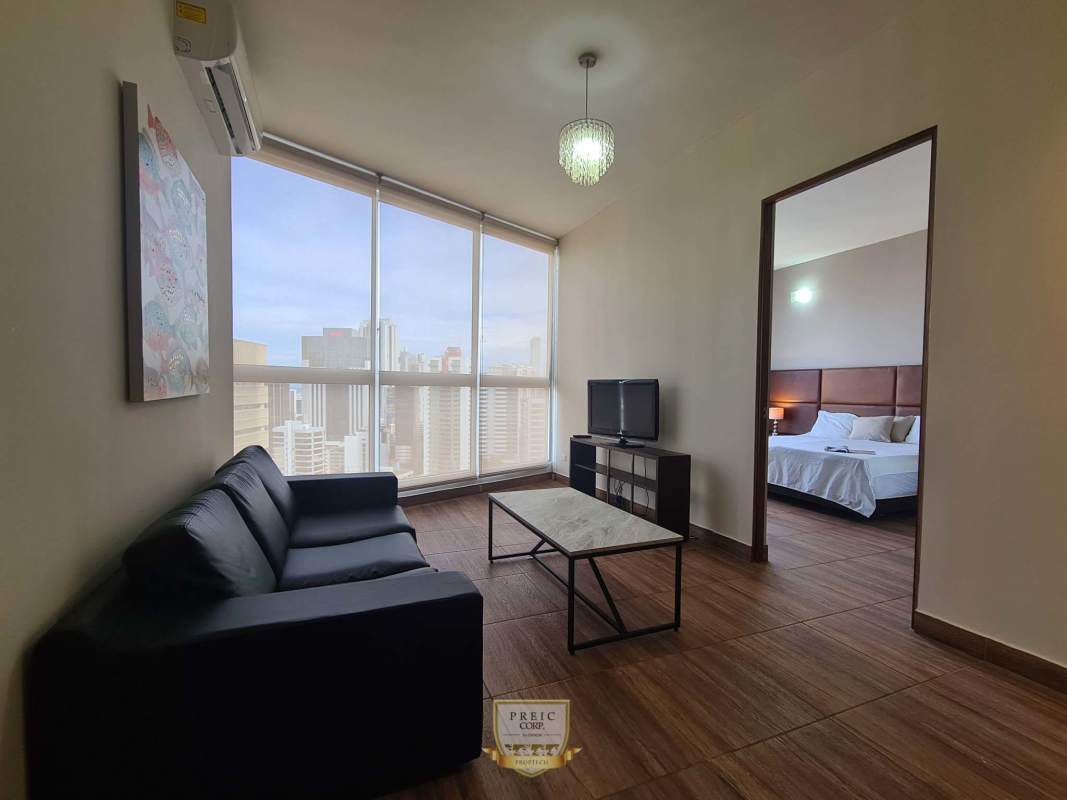 Suite bedroom with large padded headboard and city view windows PH Denovo Panama