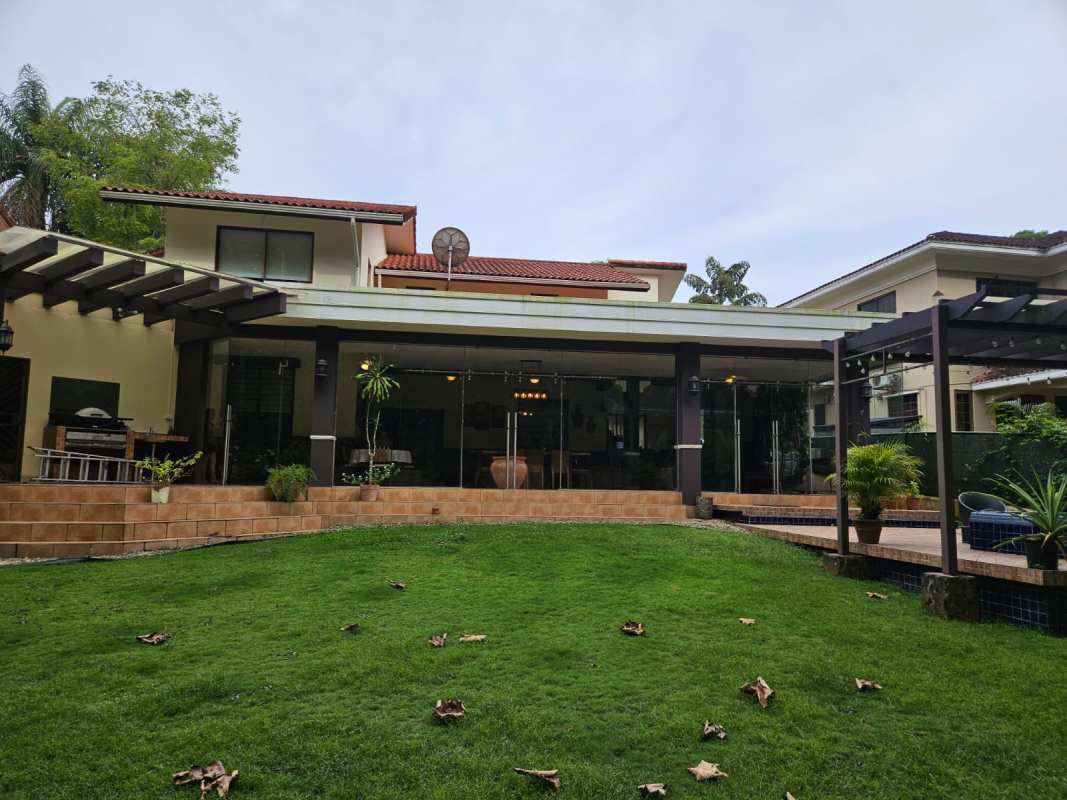 City indoor patio dining enclosed with glass tropical garden views Panama house