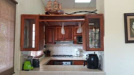 Traditional kitchen with wood cabinets and full appliances at Costa Esmeralda vacation rental Panama