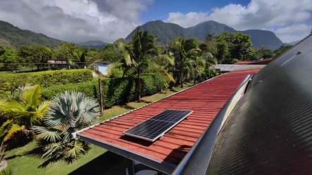 Solar panel roof with lush tropical landscape, palm trees and Coclé mountains in background