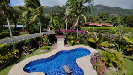 Freeform pool surrounded by lush tropical landscaping, palms and mountain views in El Valle Panama