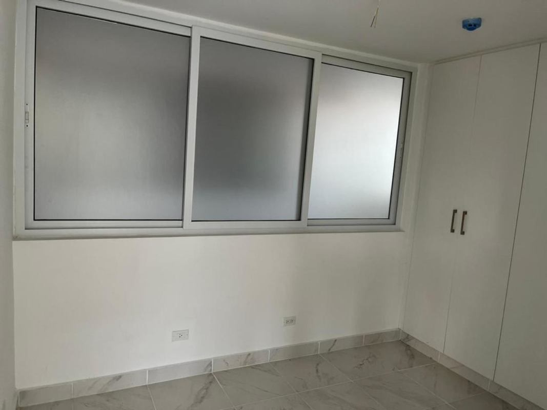 Minimalist bedroom with built-in closet and frosted glass window Mystic Gates Panama