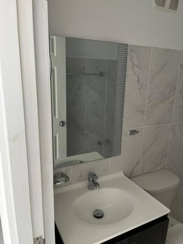 Minimalist bathroom with marble-look tiles, walk-in shower, vanity and toilet in Mystic Gates Tower 500 Panama City