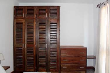 Rustic bedroom with wooden wardrobe and natural lighting in Pedasi boutique hotel Panama