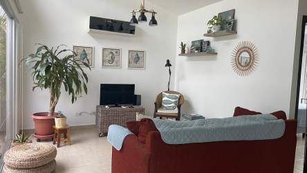 Cozy living room with red sofa, modern décor, and ample natural light in Ibiza Beach Residences Río Hato Panama