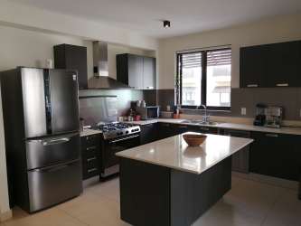 Large swimming pool surrounded by gardens at PH River Valley Panama Pacifico