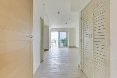 Bright corridor with wooden flooring and built-in closet doors in Surfside Playa Caracol apartment