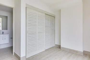 Master bedroom with tile flooring, ensuite bath access, and neutral palette in Surfside Playa Caracol Punta Chame