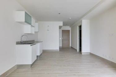 Balcony with clear glass railing overlooking infinity pool, palm trees, and Pacific Ocean in Surfside Punta Chame Panama