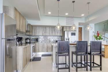 Gourmet kitchen with large island, quartz counters, stainless appliances, ocean view at Punta Caelo San Carlos Panama