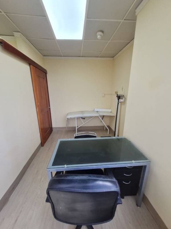 Clinical exam room with table, weighing scale and city view in Panama City