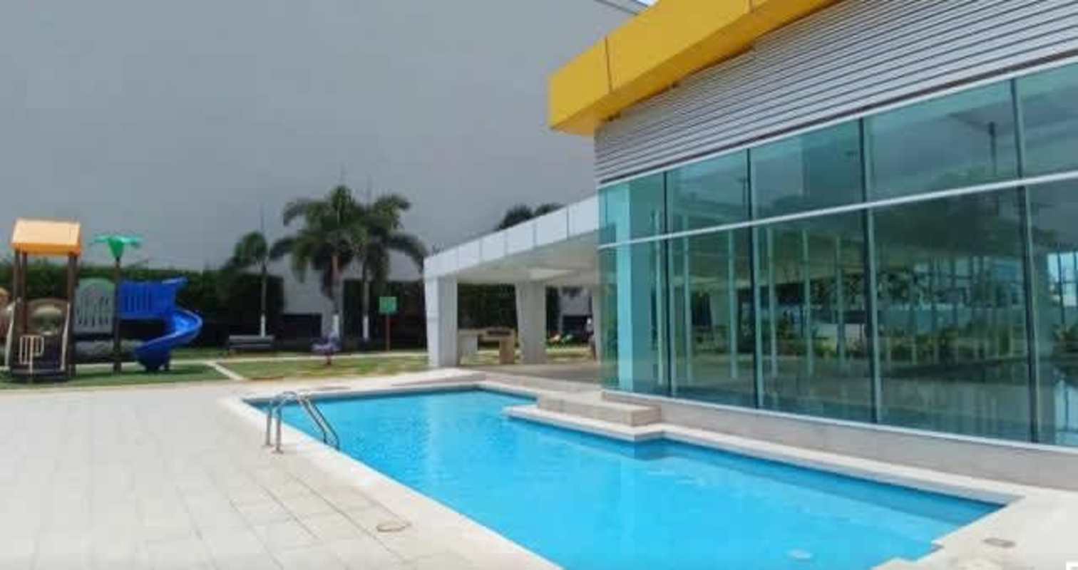 Outdoor pool area, playground and glass clubhouse in PH Kings Park Panama City