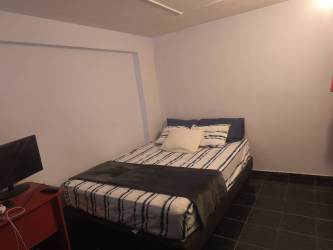 Small bedroom with TV desk blackout curtains in David budget apartment