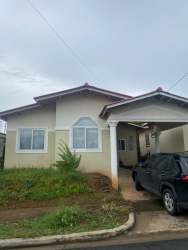 Exterior of one-story house with driveway, carport, yard in Mystic City La Chorrera Panama