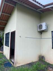 Exterior side view of suburban house with AC unit barred windows Mystic City La Chorrera