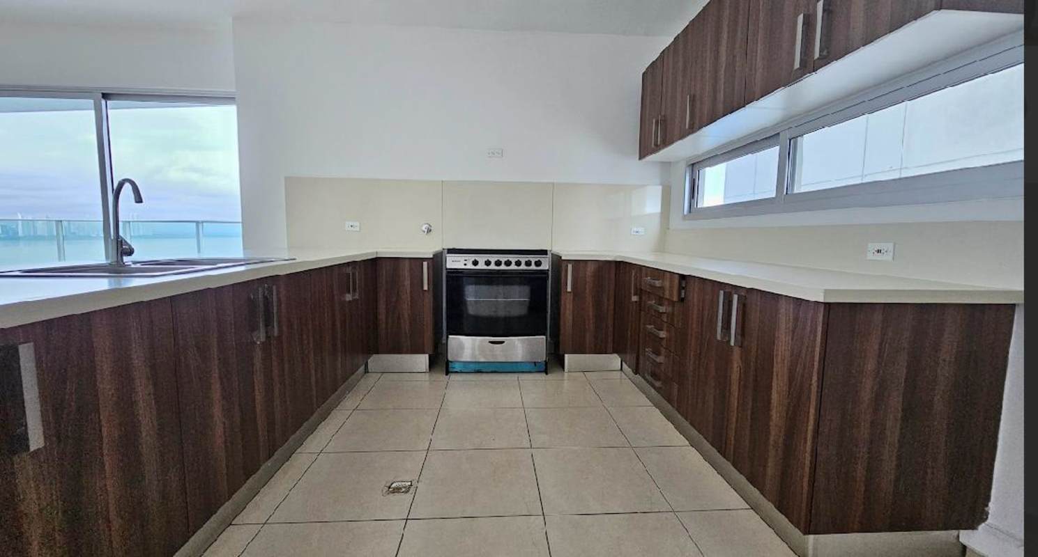 Modern kitchen with wood cabinets quartz countertops ocean view window in Punta Pacifica Panama
