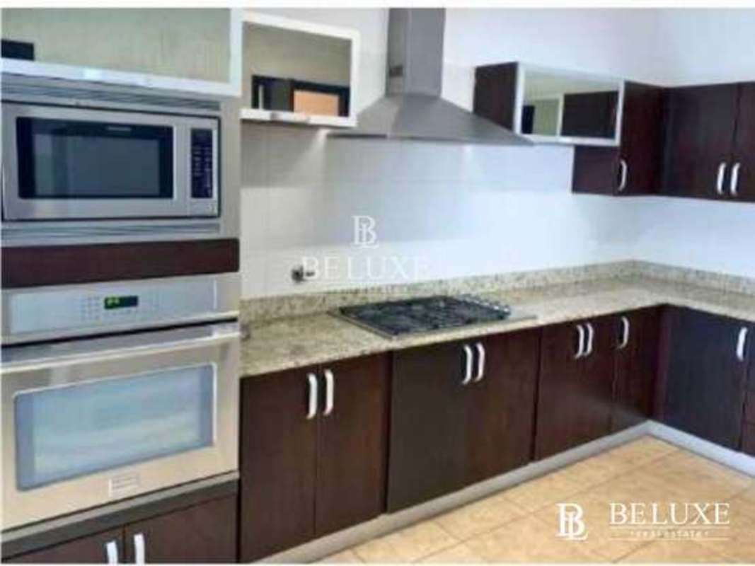 Contemporary kitchen with granite counters and built-in appliances at PH Titanium Costa del Este Panama