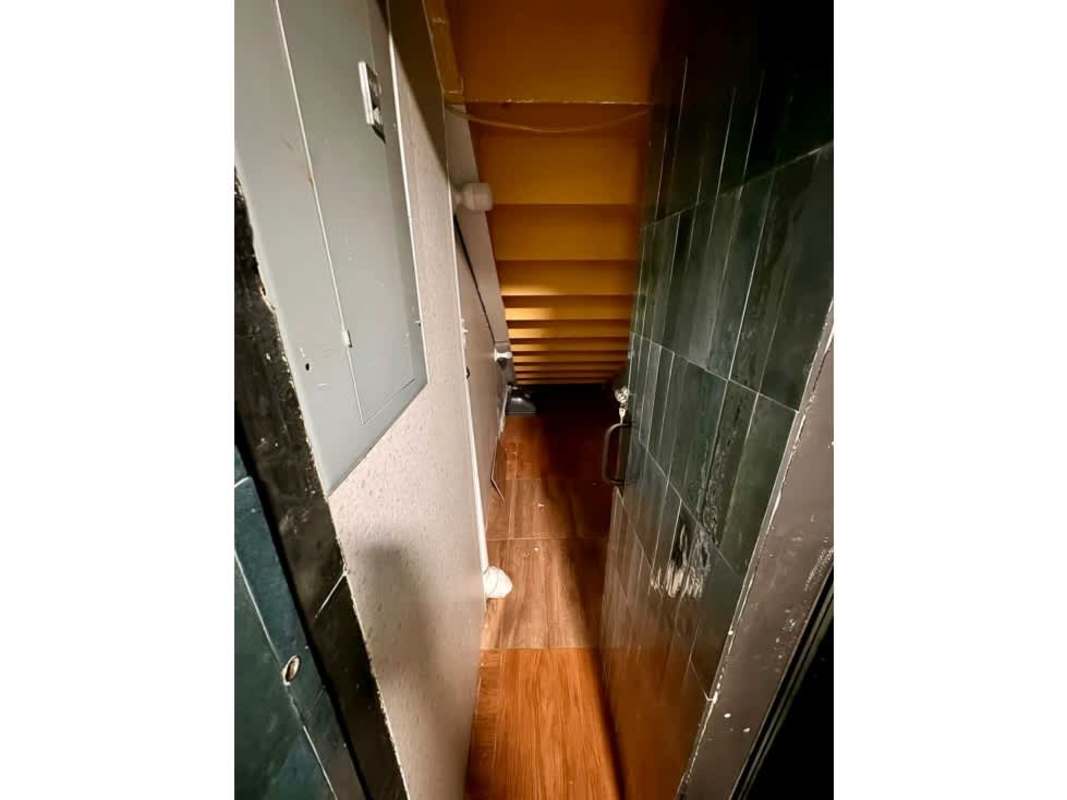 Narrow hallway storage under stairs electrical panel commercial Panama