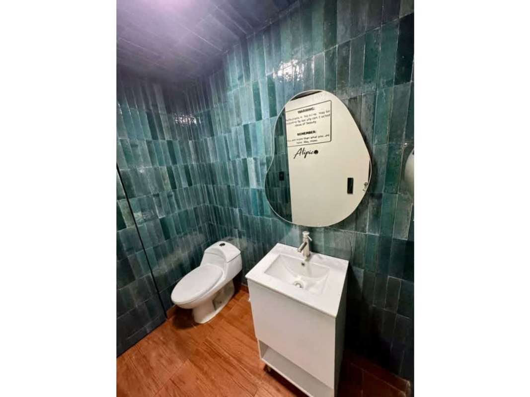 Contemporary bathroom with green tiles mirror vanity in commercial plaza San Francisco Panama