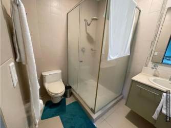 Covered balcony with patio furniture overlooking tropical gardens and swimming pools in Bijao Panama