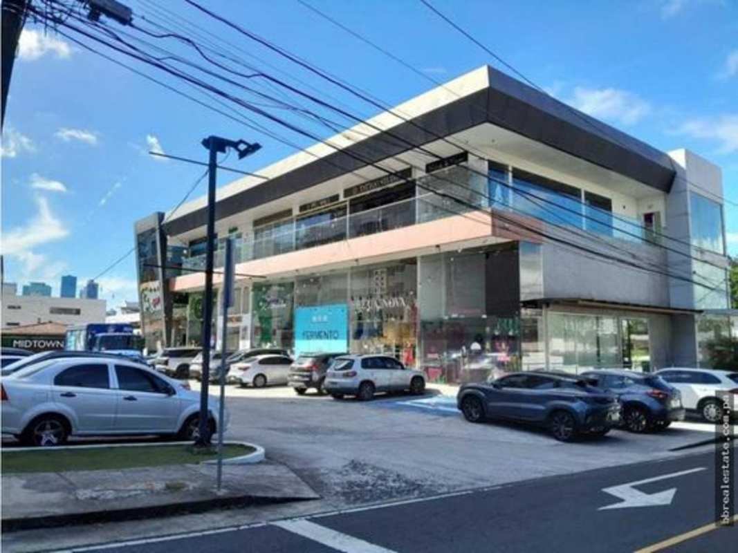 Two-story commercial plaza exterior with glass storefronts in San Francisco Panama