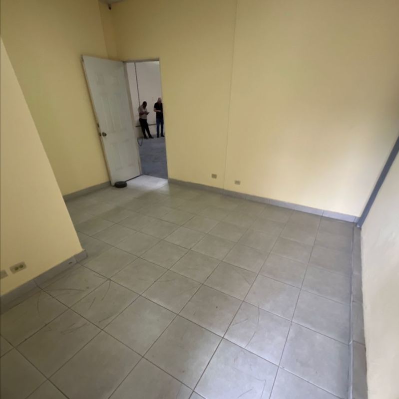 Vacant interior room with gray floor tiles and yellow walls warehouse lease Chanis Panama City