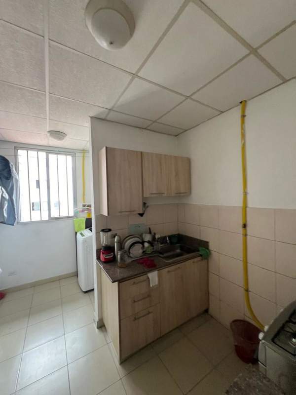 Compact kitchen with granite countertop, overhead cabinets, window, and laundry hookup PH Valentina Panama