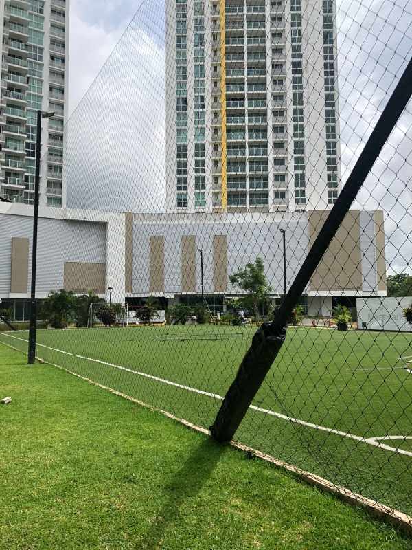 Soccer field and basketball court with towering apartment buildings in Condado del Rey