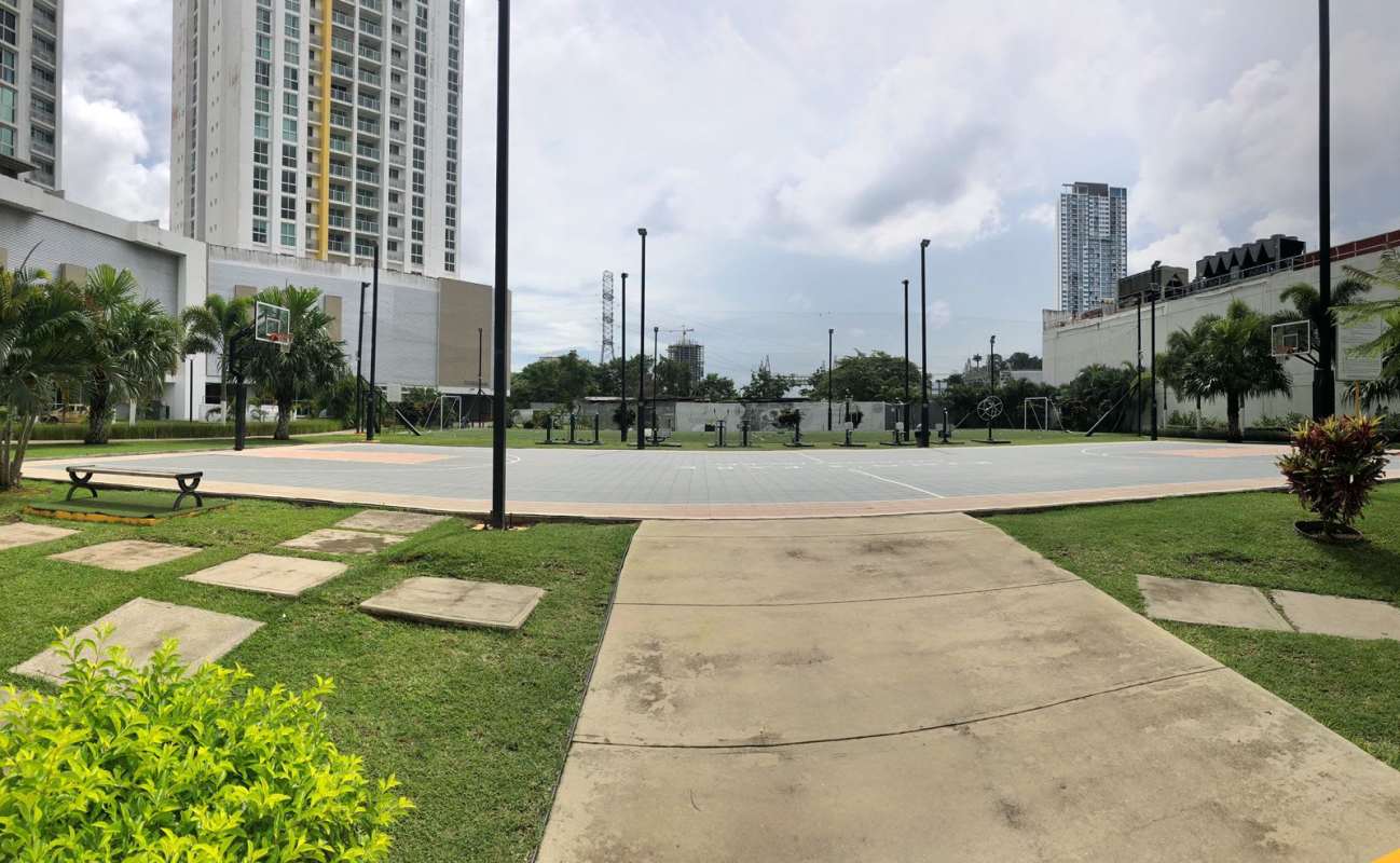 Basketball court, green lawns, outdoor seating with high-rise backdrop in PH Kings Park