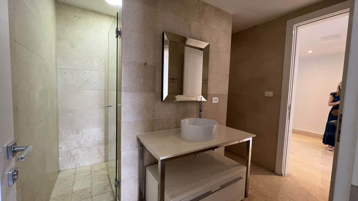 Modern bathroom with marble finishes and glass-enclosed shower in PH Yoo Panama